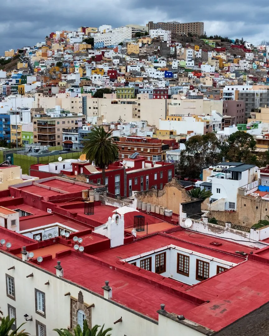Vista de Las Palmas de Gran Canaria con casas de colores en la ladera y azoteas rojas en primer plano